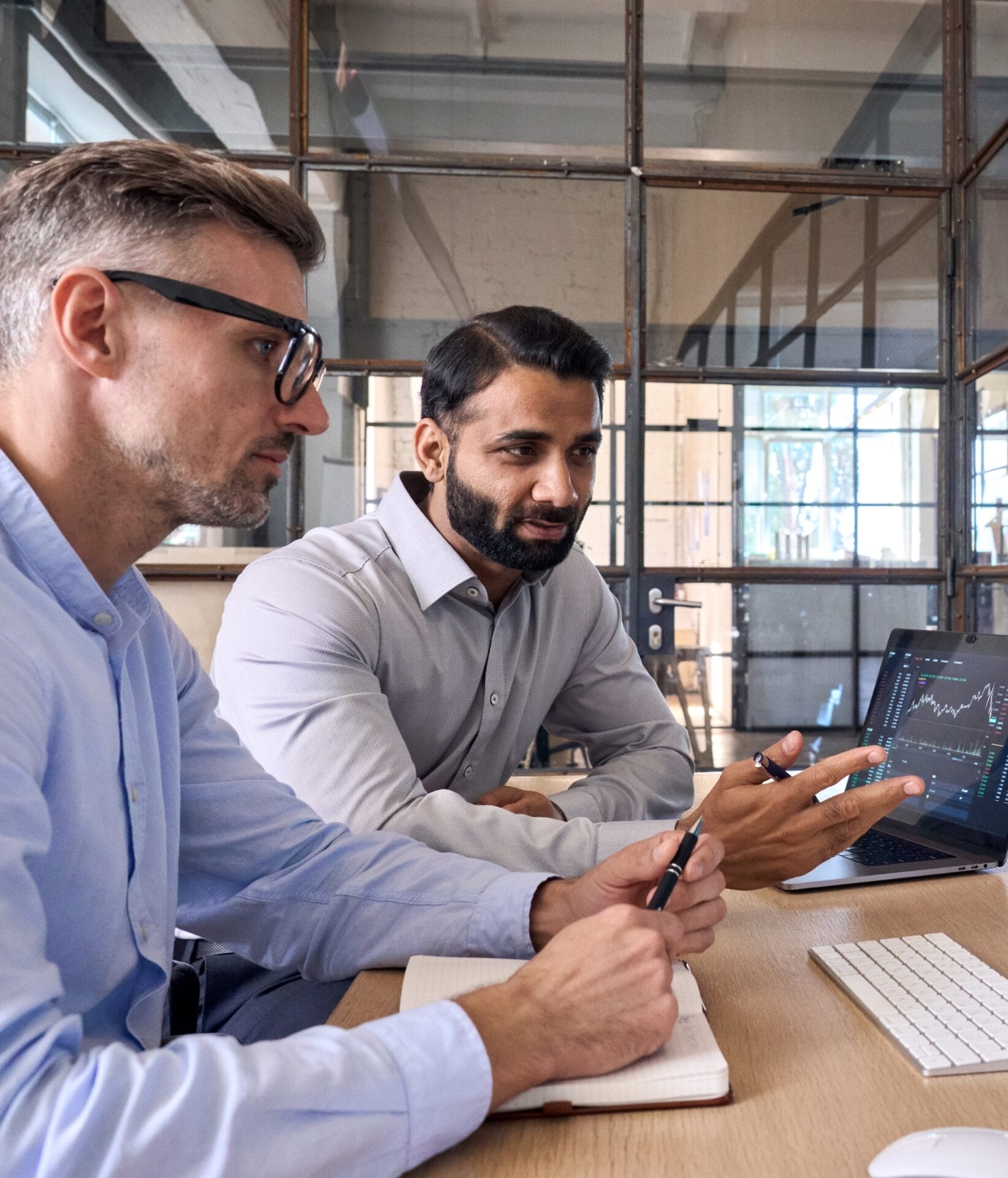 Two diverse communications professionals reviewing analytics and strategy on a desktop screen—evaluating PR performance, media risks, and campaign outcomes.